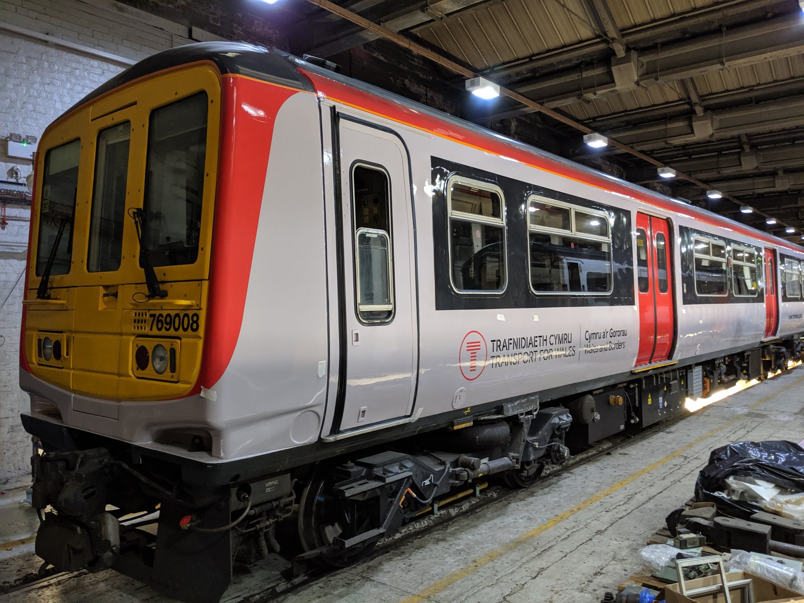Train carriage with a red, white and yellow vinyl livery